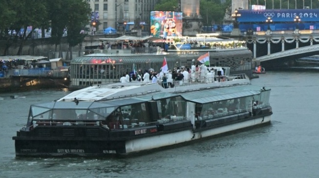 Delegasi dari India, Indonesia, dan Iran berlayar dengan perahu selama upacara pembukaan Olimpiade Paris 2024 di Paris pada 26 Juli 2024, dengan Menara Eiffel terlihat di latar belakang.Andrej ISAKOVIC / AFP