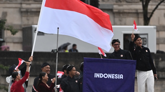 Kontingen Indonesia mengikuti defile dengan menaiki kapal menyusuri sungai Seine saat pembukaan Olimpiade Paris 2024 di Paris, Prancis, Kamis (26/7/2024). (ANTARA FOTO/Wahyu Putro)