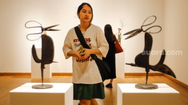 Pengunjung mengamati patung yang ditampilkan saat berkunjung ke pameran "Patung dan Aktivisme: Dolorosa Sinaga dan Budi Santoso" di Galeri Nasional Indonesia, Jakarta, Minggu (28/7/2024). [Suara.com/Alfian Winanto]