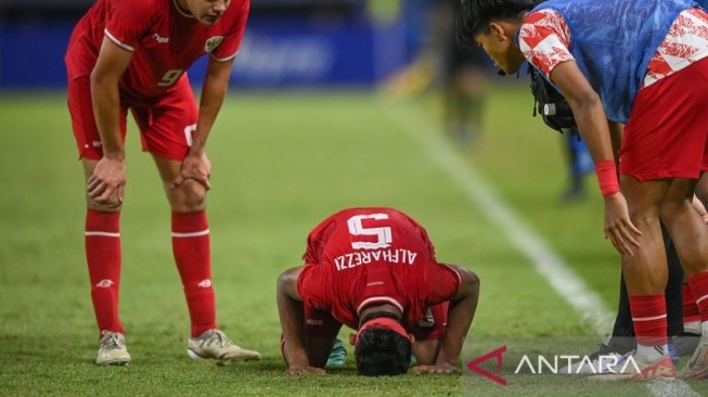 Pesepak bola Timnas Indonesia Muhammad Alfharezzi Buffon (tengah) bersujud syukur disaksikan rekan-rekannya usai membobol gawang Timnas Malaysia dalam pertandingan semifinal Piala ASEAN U-19 Boys Championship atau AFF U-19 di Stadion Gelora Bung Tomo, Surabaya, Jawa Timur, Sabtu (27/7/2024). Indonesia menang dengan skor 1-0 dan lolos ke babak final untuk bertanding melawan Timnas Thailand. ANTARA FOTO/Sigid Kurniawan/app/tom/pri. (ANTARA FOTO/SIGID KURNIAWAN)