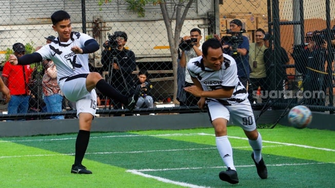 Ketua Umum PSI Kaesang Pangarep (kiri) saat bermain bola melawan tim dari Calon Kepala Daerah (Cakada) di Lapangan Gaskan Mini Soccer, Jakarta, Senin (29/7/2024). [Suara.com/Alfian Winanto]