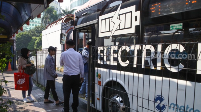 Penumpang saat menaiki bus listrik Transjakarta di Terminal Blok M, Jakarta, Senin (29/7/2024). [Suara.com/Alfian Winanto]