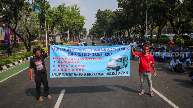 Kelompok sopir Mikrotrans atau angkot Jaklingko dan Mikrolet Jakarta melakukan aksi demonstrasi di depan Balai Kota DKI Jakarta, Selasa (30/7/2024). [Suara.com/Alfian Winanto]