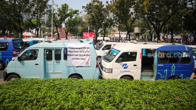 Kelompok sopir Mikrotrans atau angkot Jaklingko dan Mikrolet Jakarta melakukan aksi demonstrasi di depan Balai Kota DKI Jakarta, Selasa (30/7/2024). [Suara.com/Alfian Winanto]