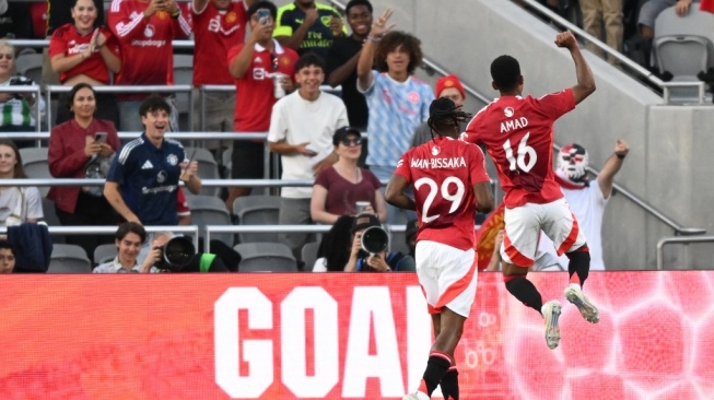 Gelandang Manchester United, Amad Diallo dan bek Aaron Wan-Bissaka merayakan gol selama pertandingan persahabatan pramusim antara Manchester United vs Real Betis di Stadion SnapDragon di San Diego, California, pada 31 Juli 2024.Patrick T. Fallon / AFP.