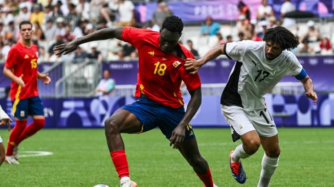 Penyerang Spanyol, Samu Omorodion berebut bola dengan gelandang Mesir, Mohamed Elneny dalam pertandingan grup C putra antara Spanyol vs Mesir selama Olimpiade Paris 2024 di Stadion Bordeaux di Bordeaux pada 30 Juli 2024.Philippe Foto: AFP/Lopez.