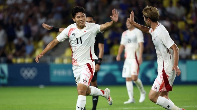 Bek Timnas Jepang, Riku Handa (kiri) merayakan kemenangan bersama rekan satu timnya di akhir pertandingan grup D putra antara Israel vs Jepang selama Olimpiade Paris 2024 di Stadion La Beaujoire di Nantes pada 30 Juli 2024.ROMAIN PERROCHEAU / AFP.