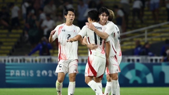 Penyerang Jepang, Mao Hosoya (kiri) merayakan kemenangan bersama rekan satu timnya setelah mencetak gol pertama mereka selama pertandingan grup D putra antara Israel vs Jepang selama Olimpiade Paris 2024 di Stadion La Beaujoire di Nantes pada 30 Juli 2024.ROMAIN PERROCHEAU / AFP