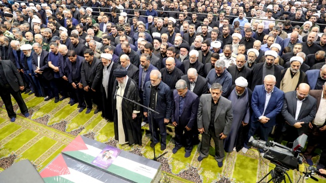 Pemimpin tertinggi Iran Ayatollah Ali Khamenei memimpin doa di depan peti jenazah mendiang pemimpin Hamas Ismail Haniyeh dan pengawalnya, selama prosesi pemakamannya di Teheran, Iran, Kamis (1/8/2024). [IRANIAN SUPREME LEADER'S WEBSITE / AFP]