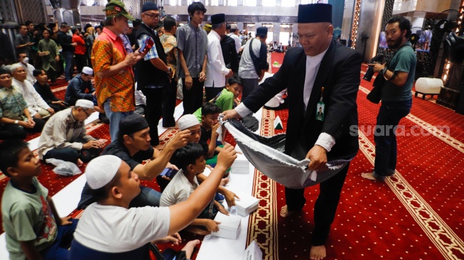 Warga berdonasi untuk Palestina usai melaksanakan salat gaib di Masjid Istiqlal, Jakarta, Jumat (2/8/2024). [Suara.com/Alfian Winanto]