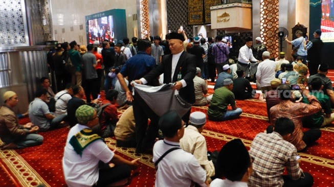 Warga berdonasi untuk Palestina usai melaksanakan salat gaib di Masjid Istiqlal, Jakarta, Jumat (2/8/2024). [Suara.com/Alfian Winanto]