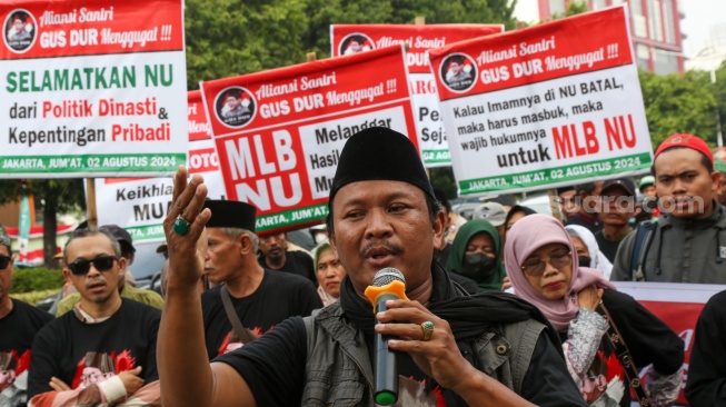 Pengunjuk rasa yang tergabung dalam Aliansi Santri Gus Dur Menggugat, Aliansi Santri Gus Dur Menggugat aksi di depan Gedung Pengurus Besar Nahdlatul Ulama (PBNU), Jakarta, Jumat (2/8/2024). [Suara.com//Alfian Winanto]