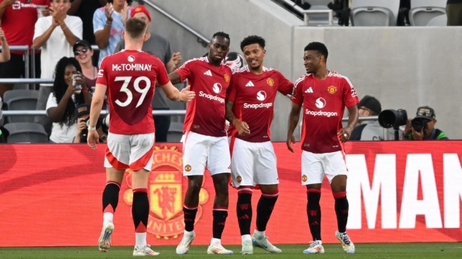 Gelandang Manchester United, Amad Diallo dan bek Manchester United, Aaron Wan-Bissaka merayakan gol selama pertandingan persahabatan pramusim antara Manchester United vs Real Betis di Stadion SnapDragon di San Diego, California, pada 31 Juli 2024.Patrick T. Fallon / AFP