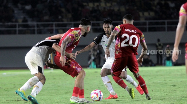 Gelandang Persija Jakarta, Resky Fandi Witriawan berusaha melewati adangan dua pemain Persis Solo laga perebutan tempat ketiga Piala Presiden 2024 di Stadion Manahan, Solo, Sabtu (3/8/2024). [Suara.com/Ronald Seger Prabowo]