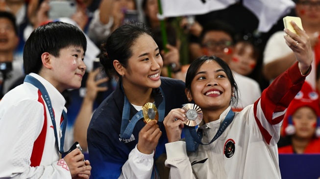 Pebulu tangkis tunggal putri Indonesia Gregoria Mariska Tunjung (kanan) berswafoto bersama pebulu tangkis Korsel An Se-young (tengah) dan He Bingjiao asal China memperlihatkan medali saat penganugerahan medali bulu tangkis tunggal Putri Olimpiade Paris 2024 di Porte De La Chapella Arena, Paris, Prancis, Senin (5/8/2024). [ANTARA FOTO/Wahyu Putro A/nz]