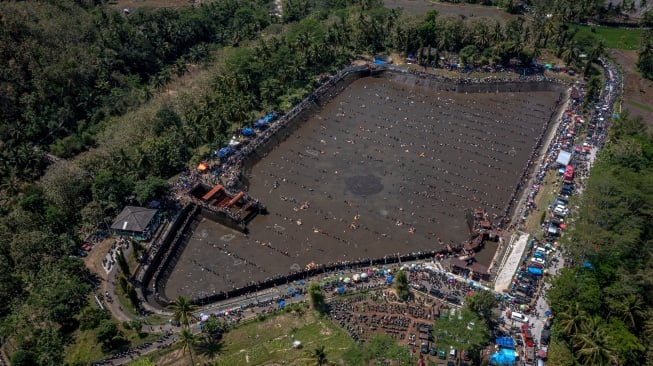 Foto udara ribuan warga menangkap ikan saat kegiatan Kurasan Kolam Tando Harian Sub Unit Pembangkit Listrik Tenaga Air (PLTA) Timo di Desa Tlompakan, Kecamatan Tuntang, Kabupaten Semarang, Jawa Tengah, Senin (5/8/2024). [ANTARA FOTO/Aji Styawan/foc]