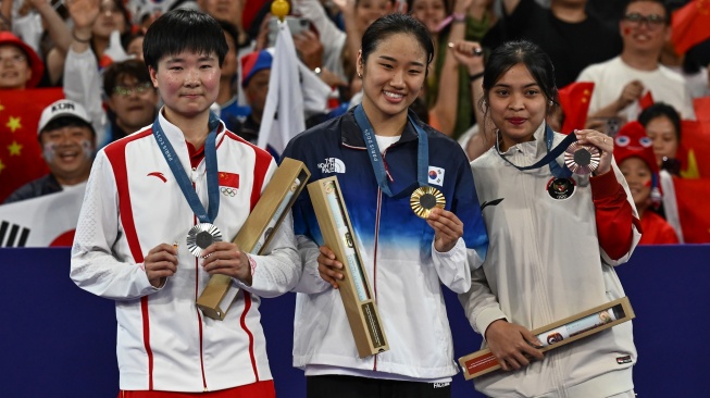 Pebulu tangkis tunggal putri Indonesia Gregoria Mariska Tunjung (kanan) bersama pebuli tangkis Korsel An Se-young (tengah) dan He Bingjiao asal China memperlihatkan medali saat penganugerahan medali bulu tangkis tunggal Putri Olimpiade Paris 2024 di Porte De La Chapella Arena, Paris, Prancis, Senin (5/8/2024). [ANTARA FOTO/Wahyu Putro A/nz]