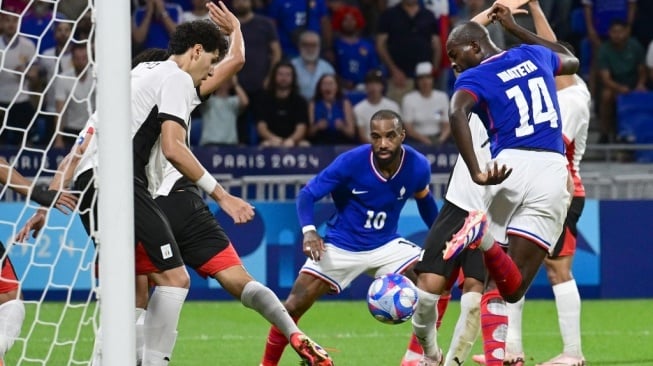 Penyerang Prancis, Jean-Philippe Mateta menendang bola untuk mencetak gol selama pertandingan semifinal sepak bola putra Olimpiade 2024 antara Prancis vs Mesir di Stadion Lyon di Lyon pada 5 Agustus 2024.Olivier CHASSIGNOLE / AFP