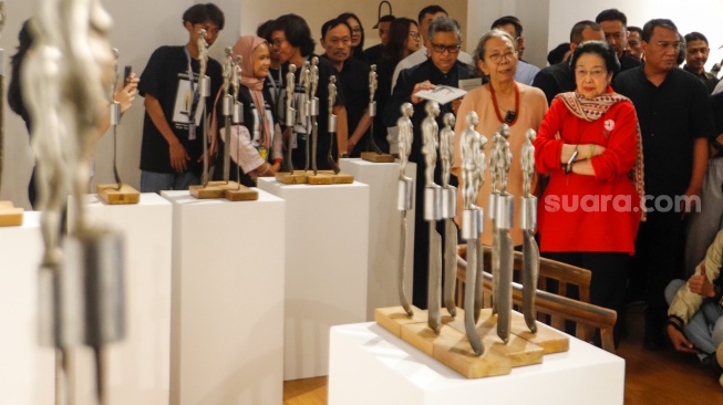 Presiden ke-5 RI Megawati Soekarnoputri (tengah) didampingi pematung Dolorosa Sinaga saat melihat pameran seni patung di Galeri Nasional, Jakarta, Kamis (8/8/20204). [Suara.com/Alfian Winanto] 