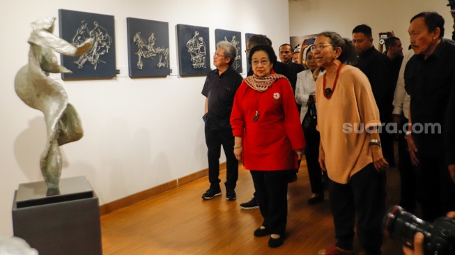 Presiden ke-5 RI Megawati Soekarnoputri (tengah) didampingi pematung Dolorosa Sinaga saat melihat pameran seni patung di Galeri Nasional, Jakarta, Kamis (8/8/20204). [Suara.com/Alfian Winanto] 
