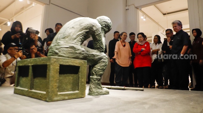 Presiden ke-5 RI Megawati Soekarnoputri (tengah) didampingi pematung Dolorosa Sinaga saat melihat pameran seni patung di Galeri Nasional, Jakarta, Kamis (8/8/20204). [Suara.com/Alfian Winanto] 