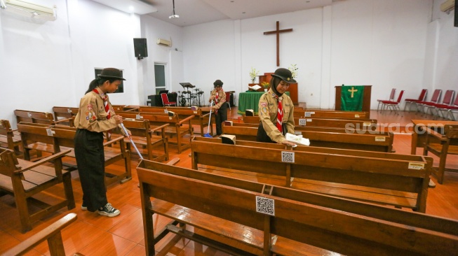 Anggota Pramuka membersihkan ruangan ibadah saat kegiatan bakti sosial pramuka di Gereja Kristen Indonesia, Kebon Bawang, Jakarta Utara, Jumat (9/8/2024). [Suara.com/Alfian Winanto]