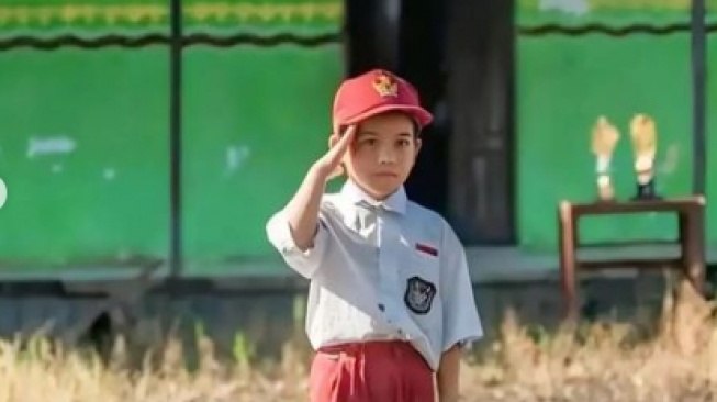 Foto siswa SD terendam lumpur di halaman sekolah saat mengikuti upacara bendera. (tangkapan layar/Instagram)