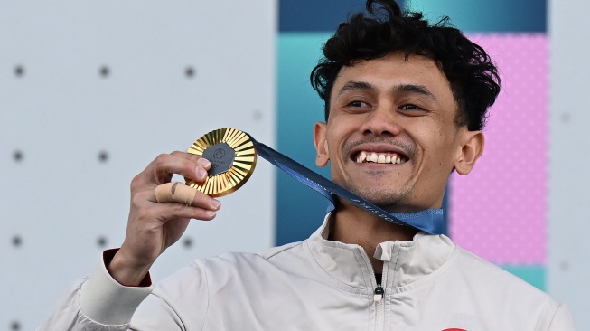 Atlet panjat tebing putra Indonesia Veddriq Leonardo menunjukkan medali emas usai menjuarai nomor speed putra Olimpiade Paris 2024 di Le Bourget Climbing Venue, Paris, Prancis, Kamis (8/8/2024). [ANTARA FOTO/Wahyu Putro A/sgd/rwa]