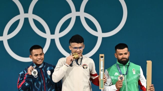 Lifter Indonesia Rizki Juniansyah (tengah) bersama lifter Thailand Wichuma Weeraphon (kiri) dan lifter Bulgaria Andreev Bozhidar Dimitrov (kanan) berpose dengan medali mereka usai upacara pengalungan medali kelas 73 kg putra Olimpiade Paris 2024 di South Paris Arena, Paris, Prancis, Kamis (8/8/2024). [ANTARA FOTO/Wahyu Putro A/app/wpa].