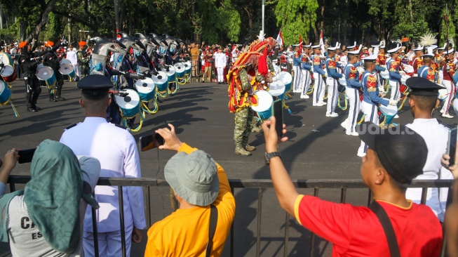 Pasukan marching band tampil saat acara kirab bendera Merah Putih dan naskah teks proklamasi menuju Ibu Kota Nusantara (IKN) di kawasan Monumen Nasional (Monas), Jakarta, Sabtu (10/8/2024). [Suara.com/Alfian Winanto]