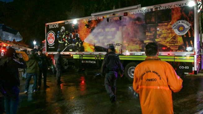 Petugas tanggap darurat bekerja di dekat reruntuhan pesawat yang jatuh Vinhedo, Sao Paulo, Brasil, Jumat (9/8/2024). [MIGUEL SCHINCARIOL / AFP]