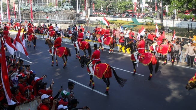 Pasukan berkuda tampil saat acara kirab bendera Merah Putih dan naskah teks proklamasi menuju Ibu Kota Nusantara (IKN) di kawasan Patung Kuda, Jakarta, Sabtu (10/8/2024). [Suara.com/Alfian Winanto]