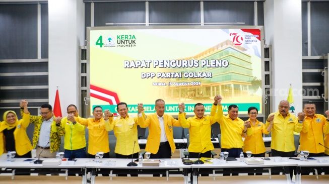 PLT Ketua Umum Partai Golkar, Agus Gumiwang Kartasasmita (tengah) bersama para Wakil Ketua Umum Partai saling bergandengan tangan saat Rapat Pengurus Pleno di Kantor DPP Partai Golkar, Jakarta, Selasa (13/8/2024). [Suara.com/Alfian Winanto]