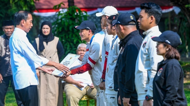 Presiden Joko Widodo (kiri) memberikan bonus kepada pemanjat tebing speed putra peraih medali emas Olimpiade Paris 2024 Veddriq Leonardo (kedua kiri) di halaman Istana Merdeka, Jakarta, Kamis (15/8/2024). [ANTARA FOTO/Muhammad Adimaja/Spt]