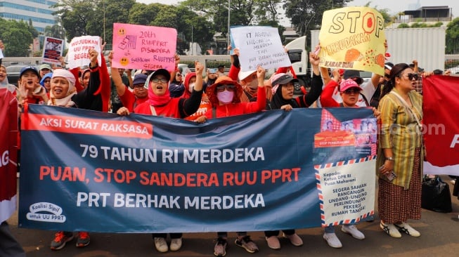 Massa dari Koalisi Sipil untuk UU PRT saat menggelar aksi di depan Gedung DPR RI, Jakarta, Kamis (15/8/2024). [Suara.com/Alfian Winanto]