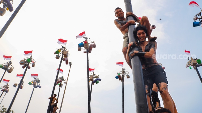 Keseruan Pengunjung Ancol Berebut Hadiah di Lomba Panjat Pinang