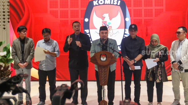 Ketua KPU Mochammad Afifuddin (tengah) memberikan pernyataan saat konferensi pers di JCC Senayan, Jakarta, Selasa (20/8/2024). [Suara.com/Alfian Winanto]