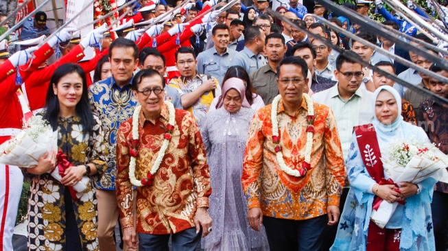 Pejabat lama Menteri Hukum dan Hak Asasi Manusia (Menkumham) Yasonna Laoly (kedua kiri) menandatangani dokumen dengan pejabat baru Menkumham Supratman Andi Agtas (kedua kanan) jalan bersama usai serah terima jabatan di Kantor Kementerian Hukum dan HAM, Jakarta, Selasa (20/8/2024). [Suara.com/Alfian Winanto]