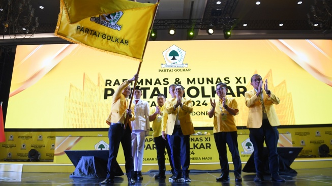 Ketua Umum Partai Golkar Bahlil Lahadalia (kiri) mengibarkan bendera partai saat Rapimnas dan Musyawarah Nasional (Munas) XI Partai Golkar 2024 di Jakarta, Rabu (21/8/2024). [ANTARA FOTO/Akbar Nugroho Gumay/aww]