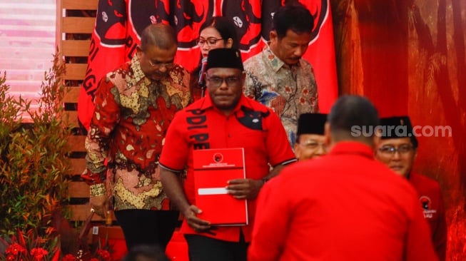 Bakal Calon Gubernur Papua Tengah Meki Fritz Nawipa (tengah) saat acara pengumuman para Calon Kepala Daerah di Kantor DPP PDIP, Jakarta, Kamis (22/8/2024). [Suara.com/Alfian Winanto]
