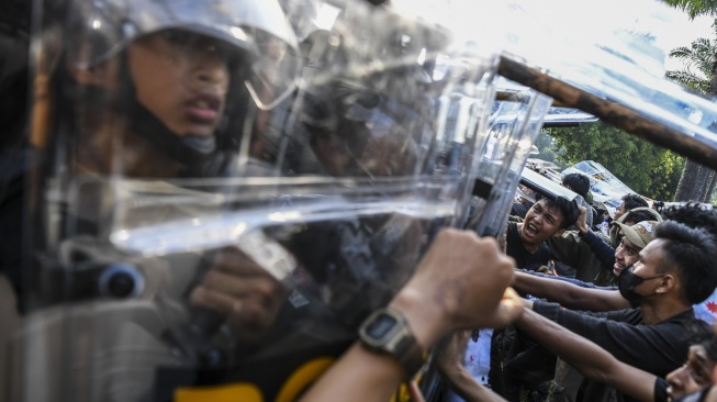 Personel kepolisian berupaya membubarkan mahasiswa yang menerobos pagar saat berunjuk rasa menolak pengesahan Revisi UU Pilkada di depan Gedung DPR, Jakarta, Kamis (22/8/2024). (ANTARA FOTO/Galih Pradipta).