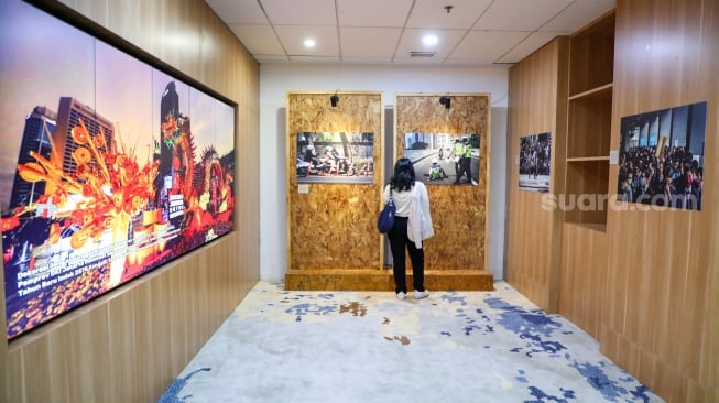 Pengunjung melihat karya foto yang dipamerkan pada pameran foto Rekam Jakarta di Perpustakaan Jakarta Galeri PDS HB Jassin, Taman Ismail Marzuki (TIM), Jakarta, Sabtu (24/08/2024). [Suara.com/Alfian Winanto]