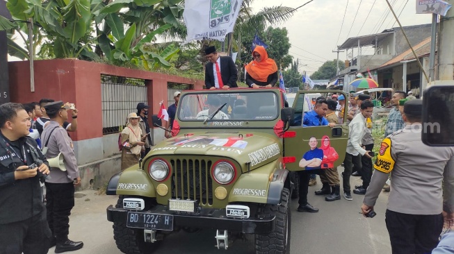 Isro Mi'raj-Nurrotul Uyun (Isro-Uyun) menaiki jeep saat mendaftar ke KPU Kota Cilegon, Rabu (28/8/2024). [Hairul Alwan/Suara.com]