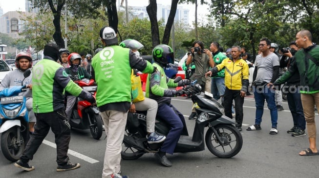 Massa pengemudi ojek online atau ojek daring melakukan aksi sweeping saat akan berunjuk rasa di kawasan Patung Kuda, Jakarta, Kamis (29/8/2024). [Suara.com/Alfian Winanto]