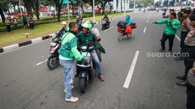 Massa pengemudi ojek online atau ojek daring melakukan aksi sweeping saat akan berunjuk rasa di kawasan Patung Kuda, Jakarta, Kamis (29/8/2024). [Suara.com/Alfian Winanto]