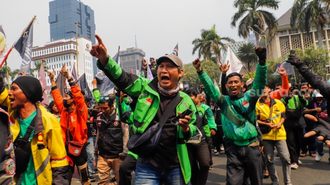 Massa pengemudi ojek online atau ojek daring berunjuk rasa di kawasan Patung Kuda, Jakarta, Kamis (29/8/2024). [Suara.com/Alfian Winanto]