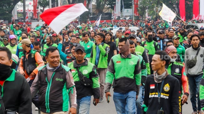 Massa pengemudi ojek online atau ojek daring berunjuk rasa di kawasan Patung Kuda, Jakarta, Kamis (29/8/2024). [Suara.com/Alfian Winanto]