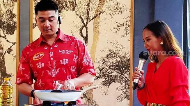 Chef Arnold demo masak nasi goreng di acara peluncuran bumbu instan Dapurasa ala Chef di Jakarta, Rabu (23/8/2024). (Foto: Suara.com/Ririn Indriani)