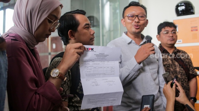 Sejumlah aktivis dari Koalisi Masyarakat Sipil untuk Reformasi Kepolisian menunjukan surat bukti pelaporan di Gedung Merah Putih KPK, Jakarta, Senin (2/9/2024). [Suara.com/Alfian Winanto]