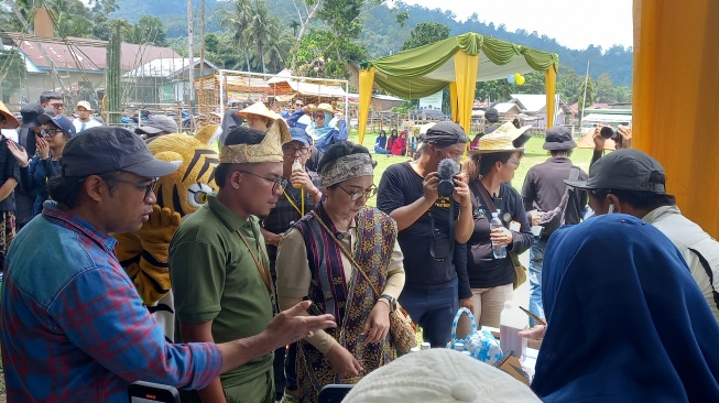 Director of Conservation and Sustainability Yapeka, Agustinus Wijayanto menjelaskan kepada Direktur Tata Kelola Destinasi Kemenparekraf, Florida Pardosi tentang produk lokal masyarakat Rimbang Baling di Karimba Fest 2024, Sabtu (31/8/2024). [Suara.com/Eko Faizin]